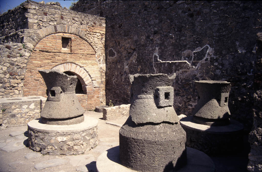 Ancient bakery remains in Pompeii, including millstones and a brick oven.